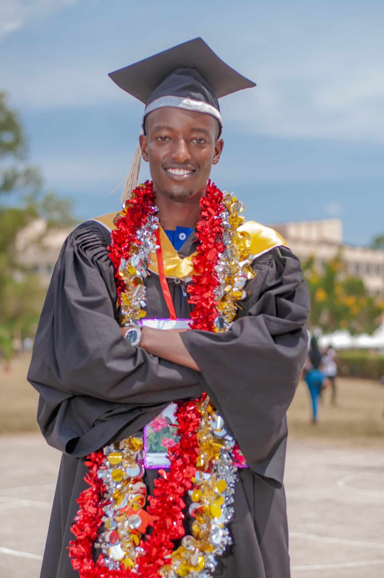 Graduate in cap and gown with celebratory garlands